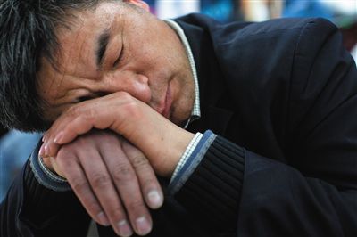 2015年3月26日，郭刚堂坐在影院外椅子上，靠着椅背休息。