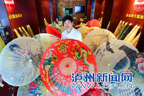 毕六福展示获奖的《龙凤呈祥》油纸伞