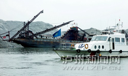 检查人员乘船巡江检查沿江两岸的禁采工作