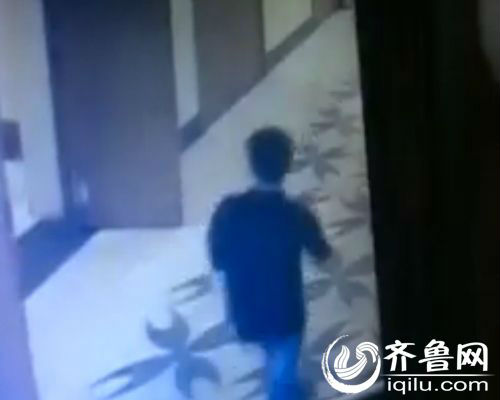 通过一楼楼道的监控可以看到，一名身穿黑色T恤黑色牛仔裤的年轻男子，进了小张家所在的济南城基中心A18号楼。（视频截图）