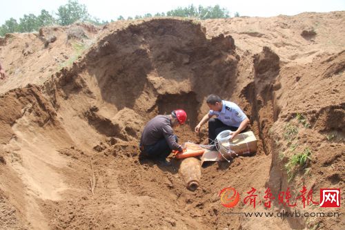 排爆专家和民警在沙塘内小心翼翼地安置航弹