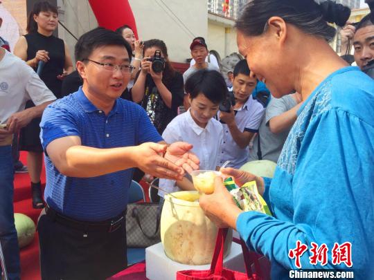 万荣县县长李永辉为市民送上免费品尝的三白瓜。　任丽娜摄