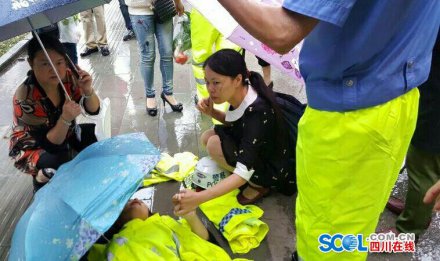 泸州女子摔倒在地 交警脱衣为其遮雨