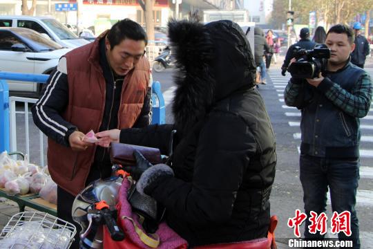 图为爱心人士购买张建永的产品。　韩冰 摄