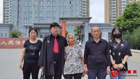  代理律师周兆成与被害人家属在法院门口合影。 受访者供图