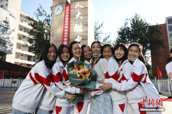资料图：6月10日，在北京人大附中高考考点外，考生们相拥拍照留念。当日，北京市2021年高考结束。　 <a target='_blank'  data-cke-saved-href='http://www.chinanews.com/' href='http://www.chinanews.com/'><p  align=