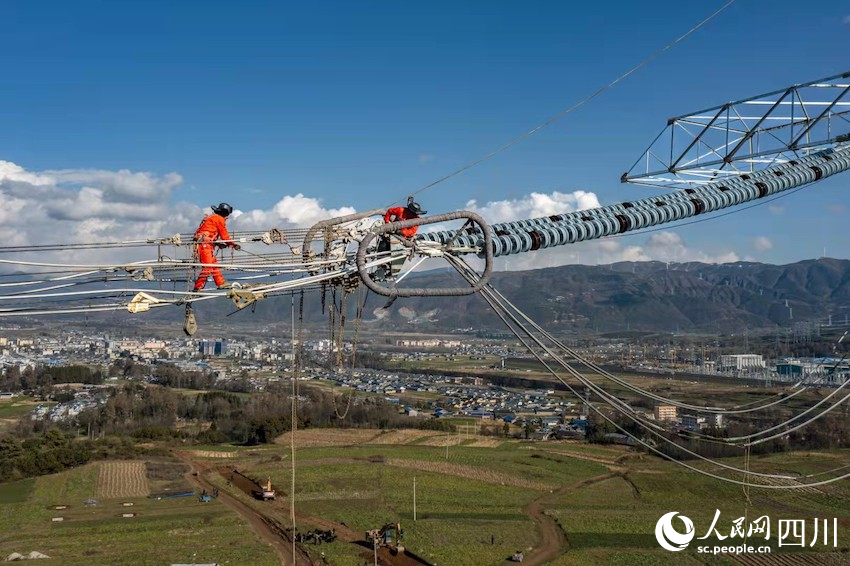 2021年11月29日，国网四川电力送变电建设有限公司员工在±800千伏“白江线”N0021～N0022号塔进行展放导线工作。安伟摄