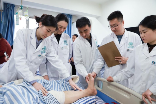 成都风湿医院痛风科门诊主任团队正在检查病人情况。成都风湿医院供图